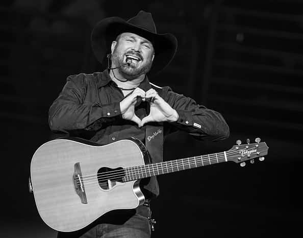 Garth Brooks on stage making a heart with his hands