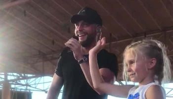 Chris Lane and young girl on stage at Ruoff Home Mortgage Music Center
