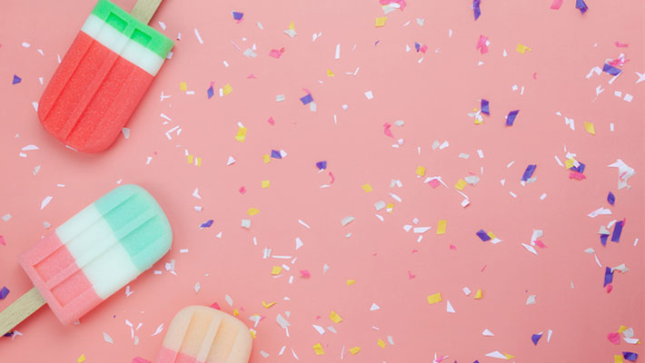 Popsicles on a pink background with confetti