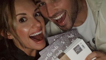 Michael Ray and Carly Pearce smiling and holding up their save the date cards