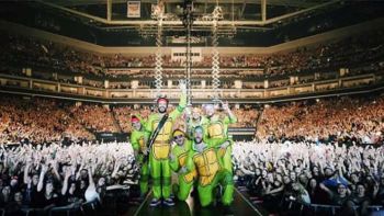 Thomas Rhett and his band onstage dressed up in Ninja Turtle Halloween costumes