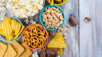 Assortment of unhealthy snacks on grey wood background