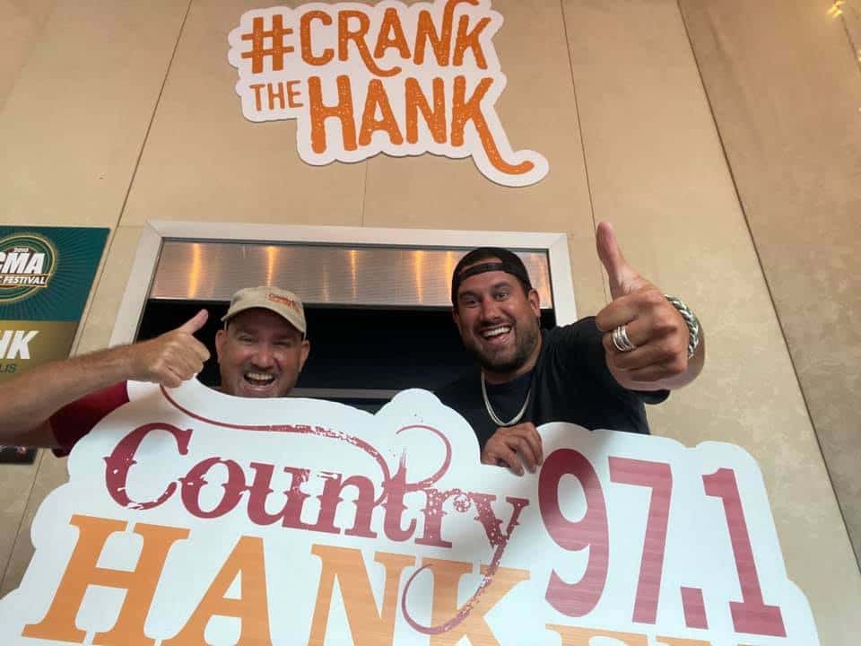 CW and Caleb holding the HANK-FM sign