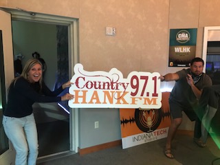Mindy and Caleb holding HANK-FM sign