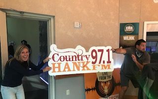 Mindy and Caleb holding HANK-FM sign