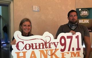 Mindy and Caleb holding HANK-FM sign