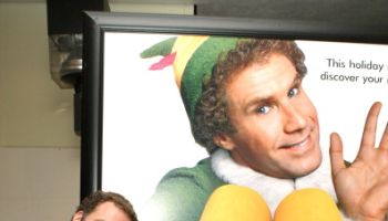 Will Ferrell standing next to an Elf Poster
