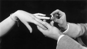 Man putting ring on woman's finger