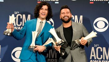 Dan + Shay holding a bunch of trophies