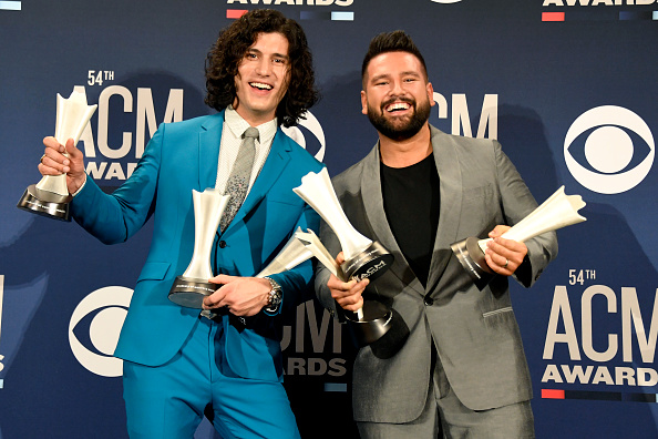Dan + Shay holding a bunch of trophies