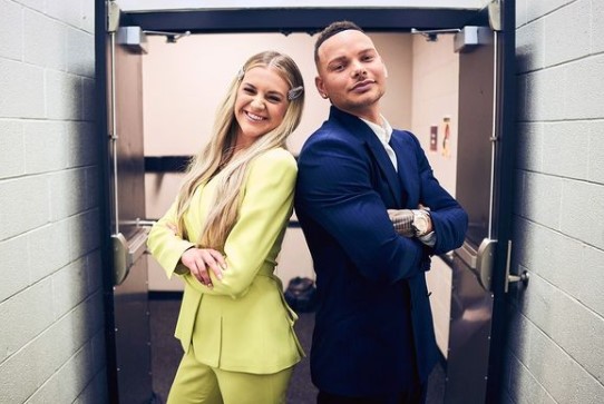Kane Brown and Kelsea Ballerini standing back to back in the doorway at the CMT Award Show