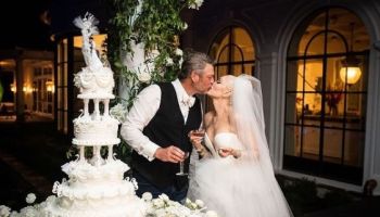 Blake Shelton and Gwen Stefani cutting cake and kissing at their wedding
