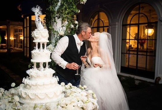 Blake Shelton and Gwen Stefani cutting cake and kissing at their wedding