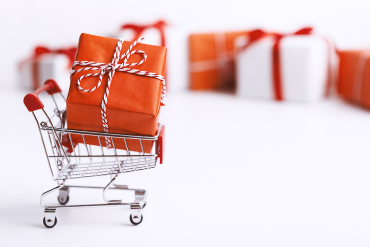 Small cart with Christmas gift box on blurred background