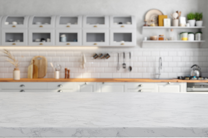 Empty White Marble Countertop With Blurred Kitchen Cabinets In The Background