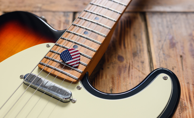 American music. Pick with flag of the United States on electric guitar. Close-up, selective focus