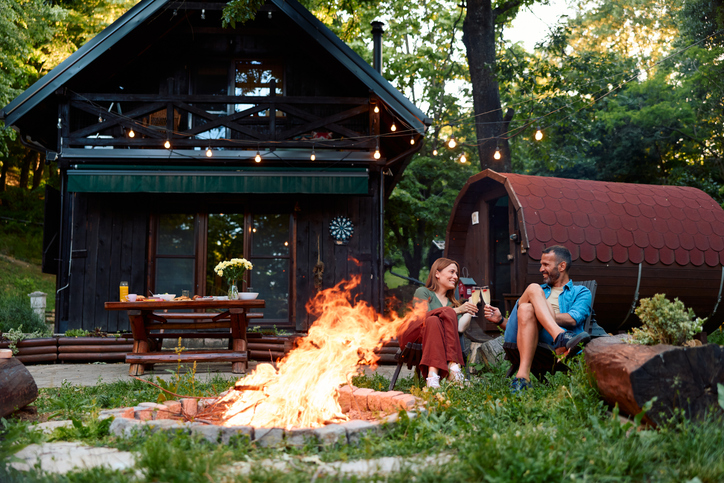 Couple enjoying campfire drinks at rural cabin resort