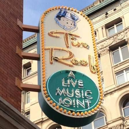 Neon sign for "The Roxy" live music venue, with a cartoon character mascot and the text "A LIVE MUSIC JOINT".