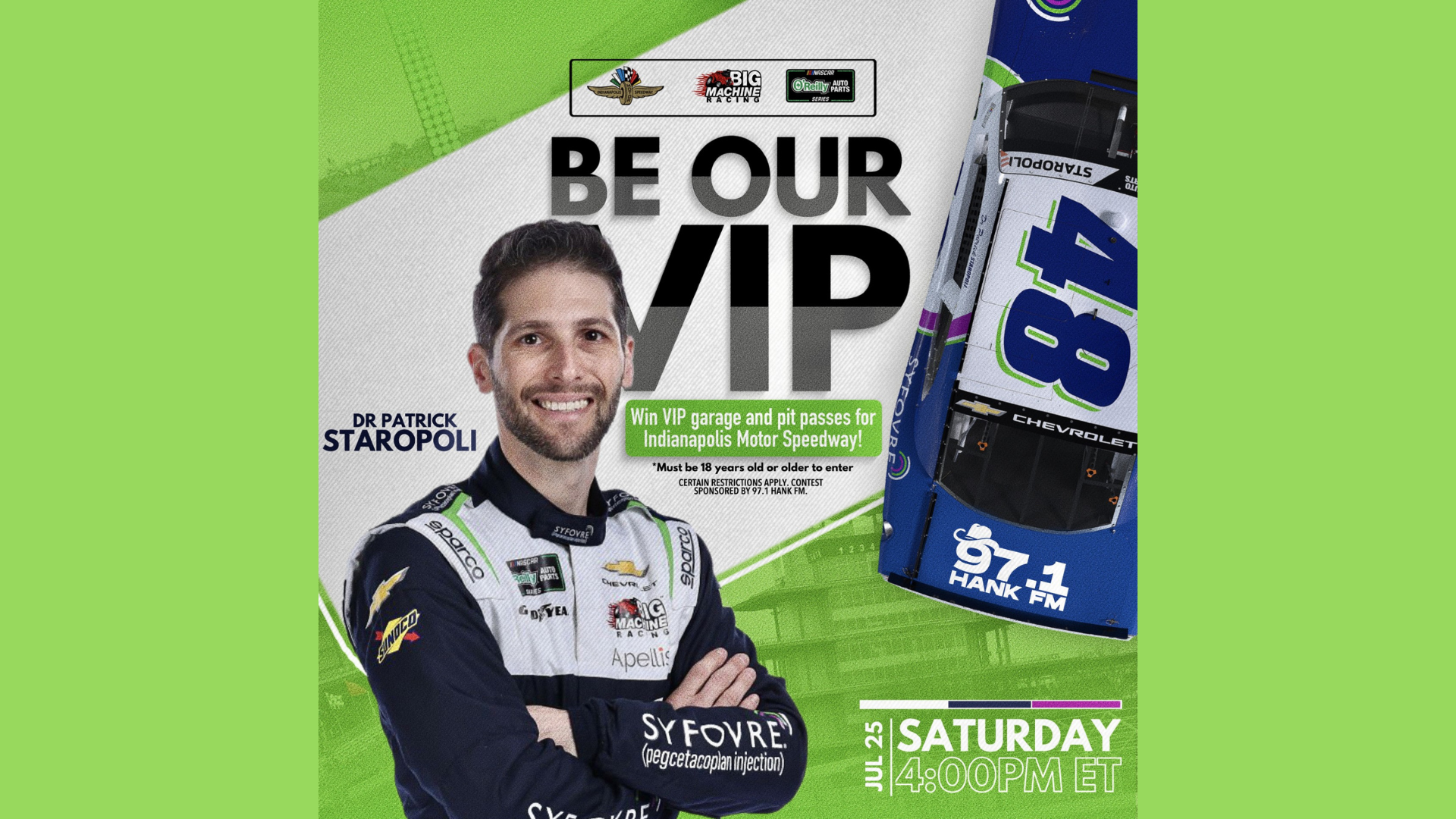 A smiling man in a racing uniform stands in front of a "Be Our VIP" promotional display for Indianapolis Motor Speedway.